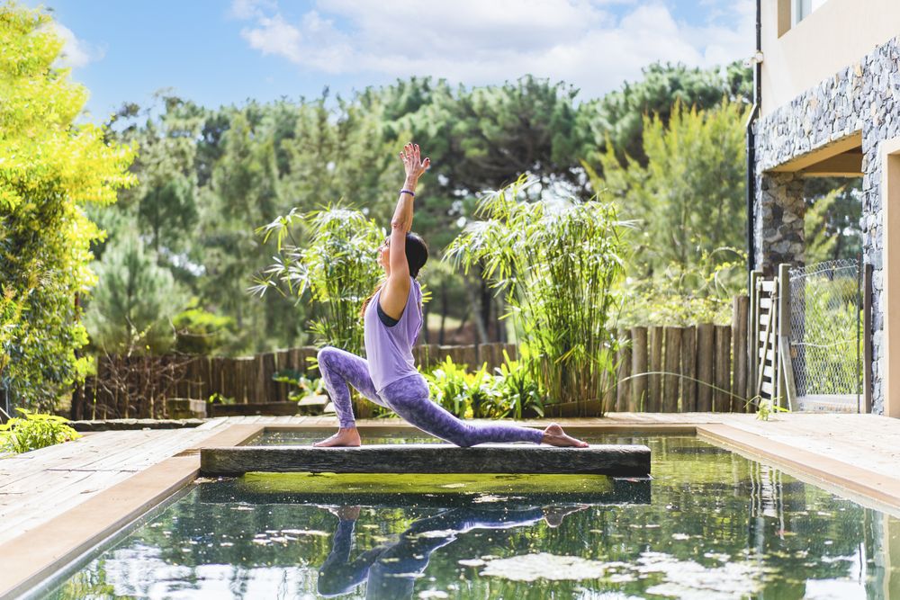 A woman practicing the yoga pose Crescent Lunge on the Knee (Anjaneyasana)