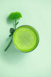 Top view of green tea on green table with flower