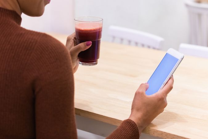 Anonymous Black woman using mobile phone in cafe
