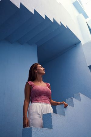 Woman walking upstairs on modern blue building