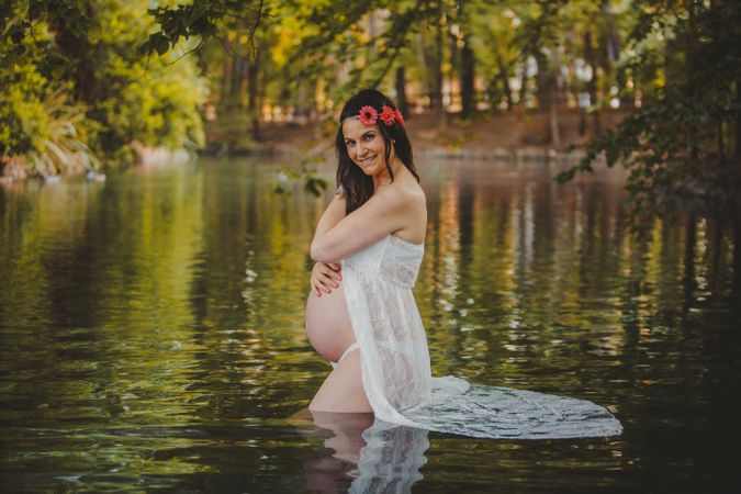Pregnant woman standing in lake water