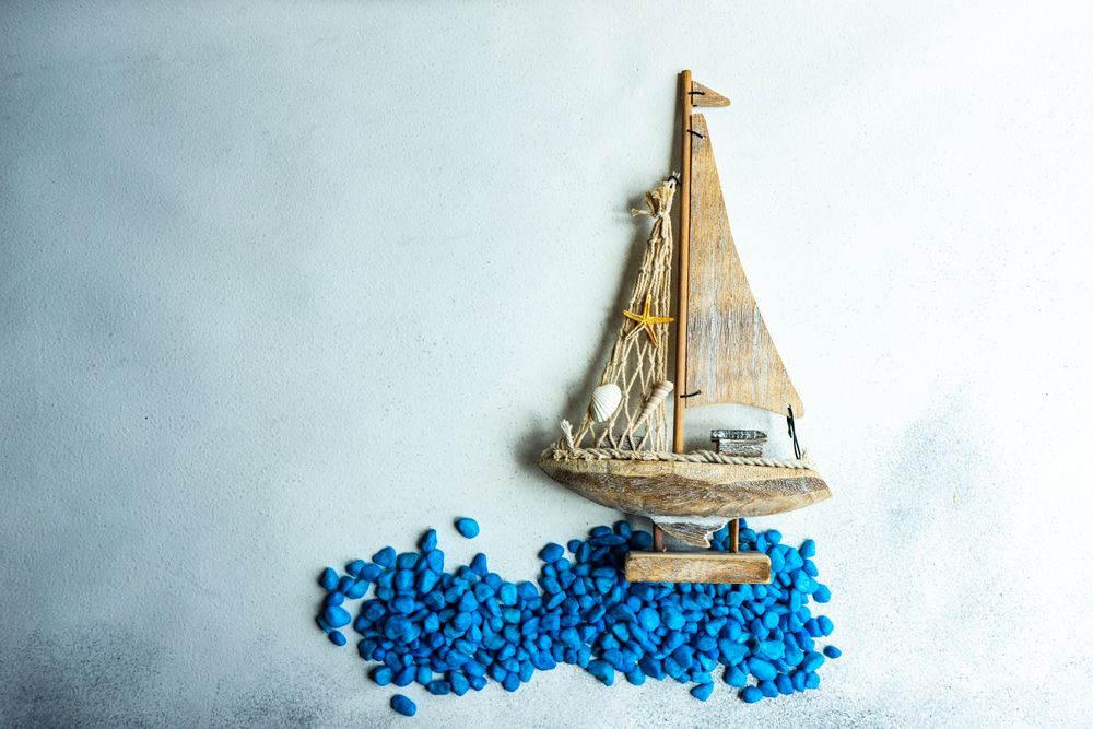 Sail boat flat lay with blue rocks