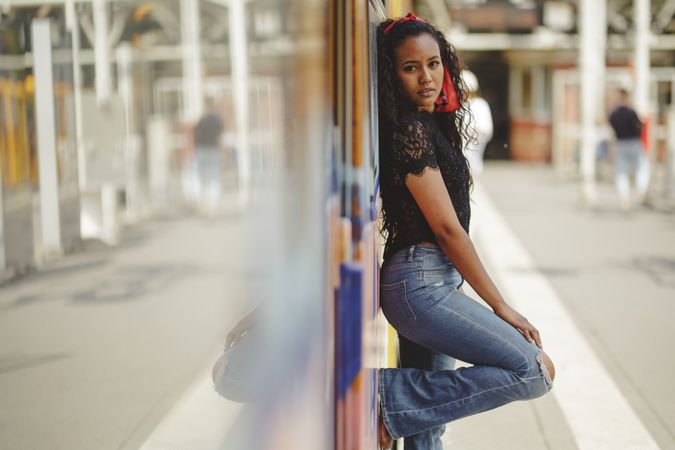 Cheerful hispanic woman standing on train