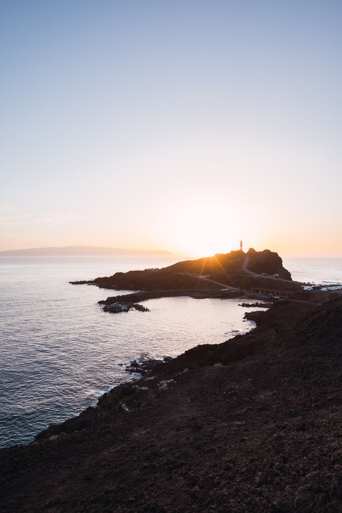 Picturesque sunset beams above cliff on seaside