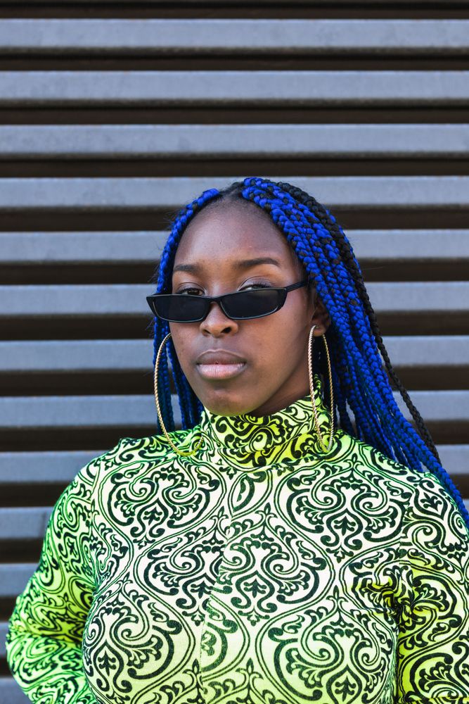 Determined Black woman in trendy clothes in city