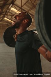 Man screaming while exercising with heavy weights in fitness studio 48l7J4