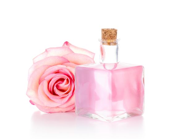 Rose water bottle on light background with rose