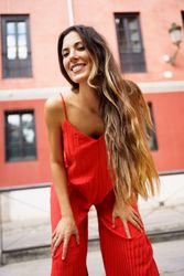 An Elegant and Stylish Woman Dressed in a Vibrant Red Outfit Posing Outdoors Gracefully