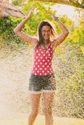 Cheerful teenager having fun with jet of water