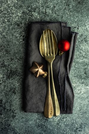 Top view of cutlery on dark napkin with ornament