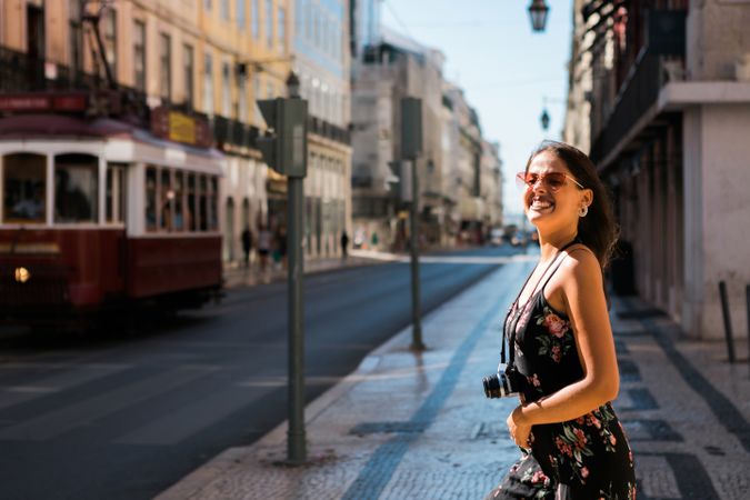 Woman holding a camera while standing on street