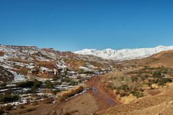 Ancient city near river between hills in snow and wonderful sky