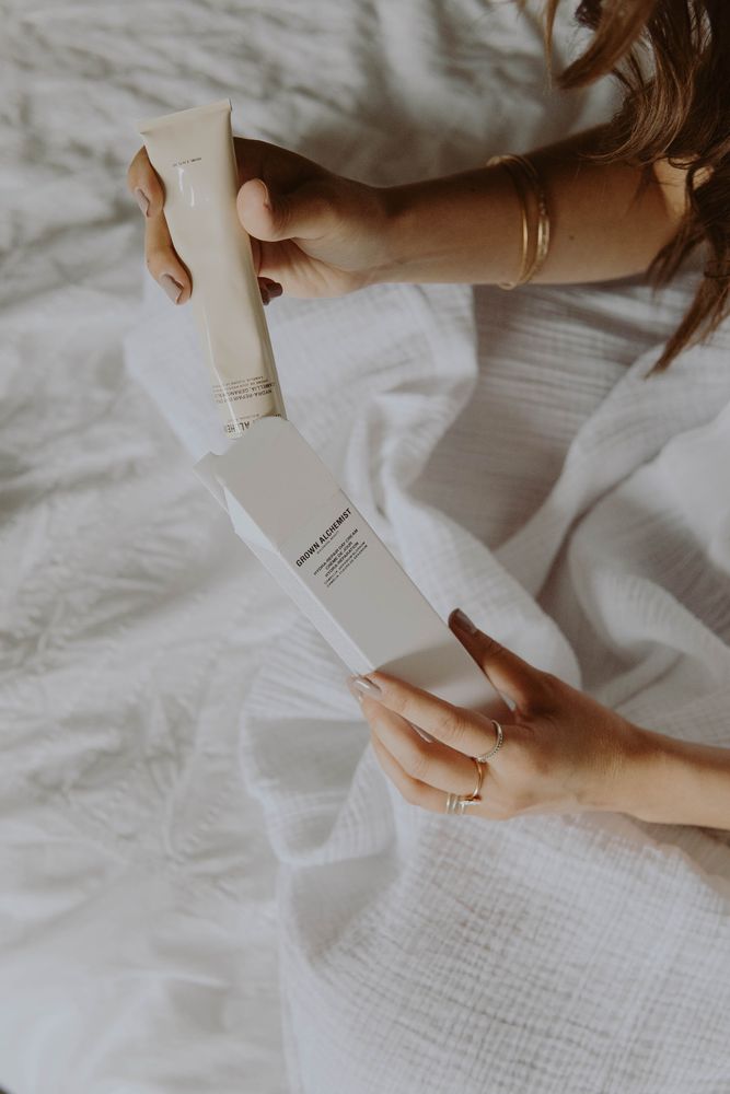 Cropped image of woman taking out a tube from the packaging