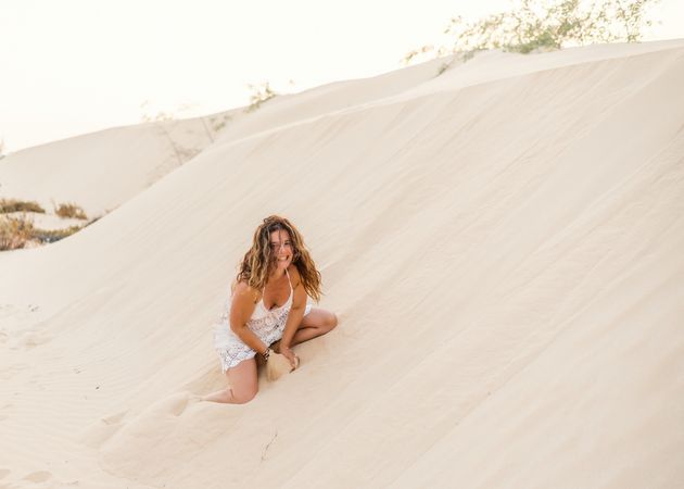 Woman sitting on sand in desert