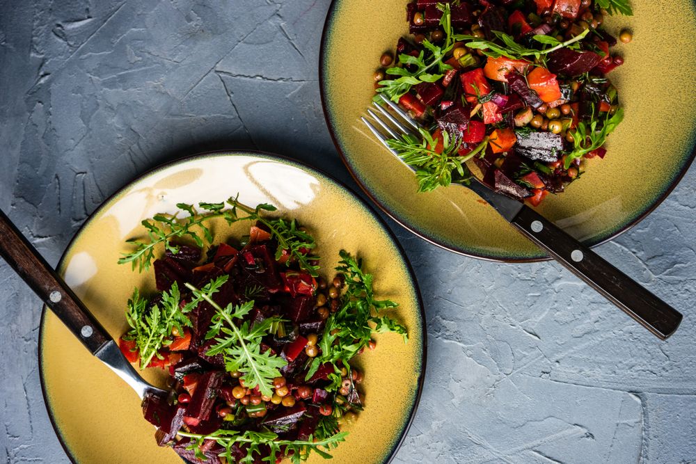 Top view of two beet salads served on yellow plates