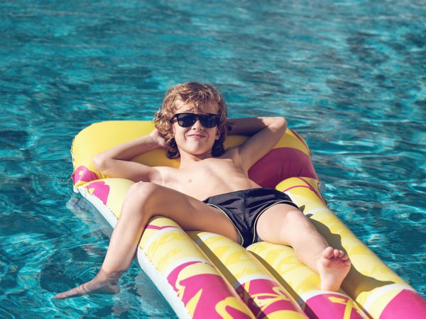 Glad boy spending time in swimming pool