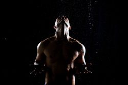 Muscular male under rain