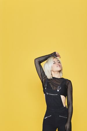 female in dark clothes in yellow studio