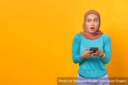 Surprised Muslim woman holding her phone 5leeo4