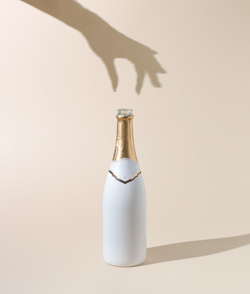 Champagne bottle with woman’s hand shadow