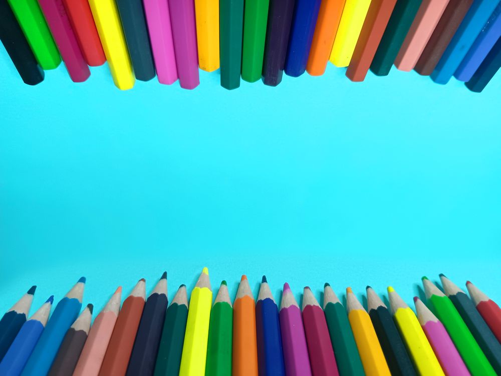color pencils on a light blue background provide space for writing or words