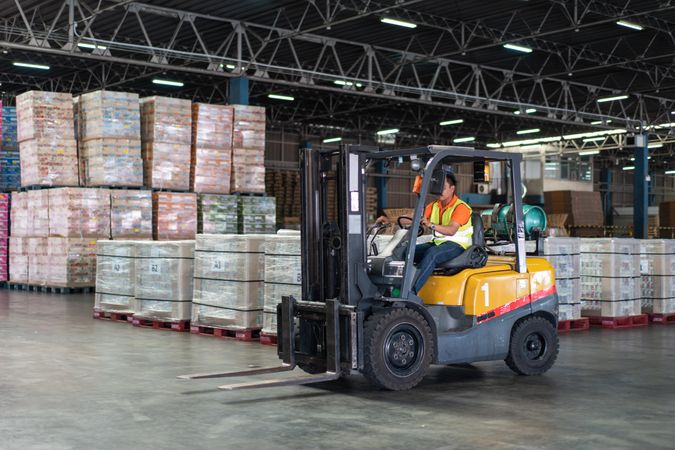 Man driving forklift in warehouse