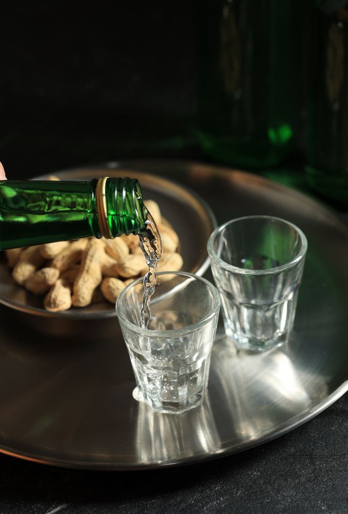 Pouring Soju or Mineral Water to Small Glass Cup.