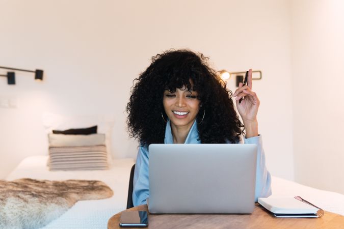 Smiling Black woman working on laptop at home