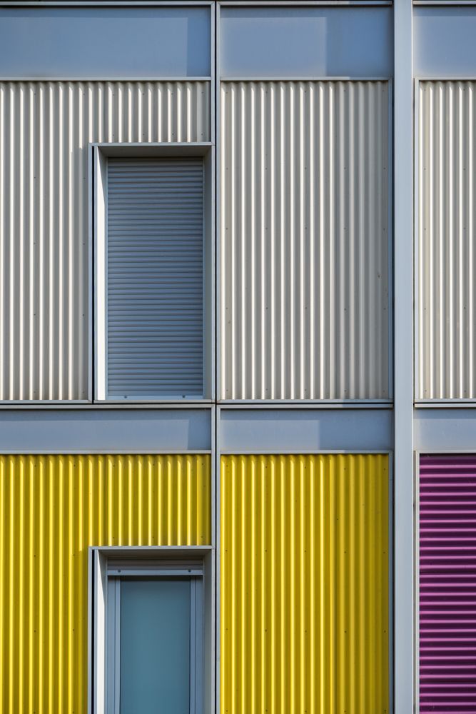 Facade of modern multicolored building with narrow windows