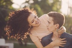 Cute teenage couple with girl holding boyfriend from behind