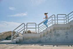 Runner jogging on staircase during workout in sunlight