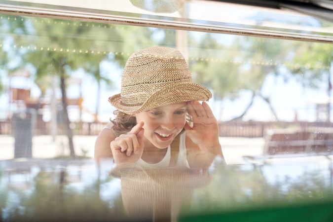 Excited child near showcase of ice cream parlor