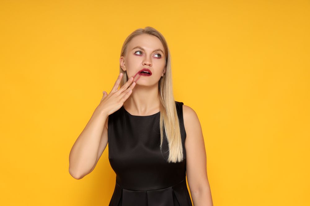 Concept of Halloween, young woman on yellow background