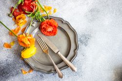 Rustic table setting with grey plate and fresh flowers with copy space
