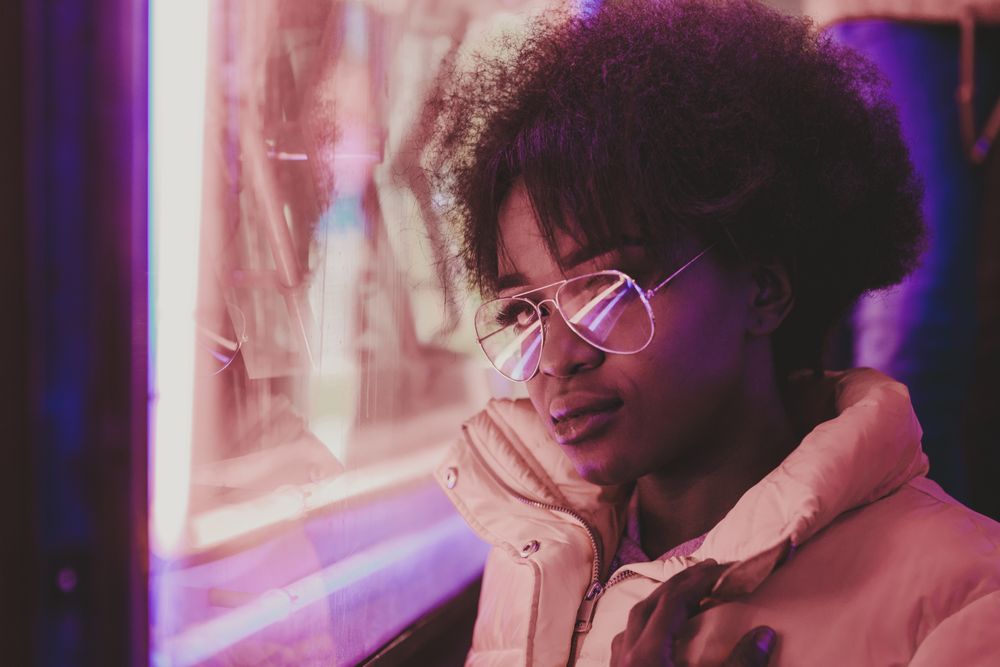 Black woman standing on night city street