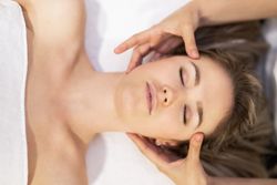 Blonde woman receiving a head massage in a spa center