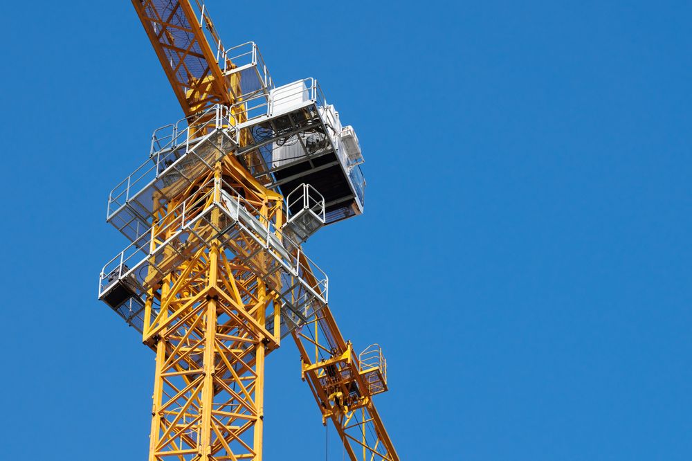 Yellow Construction Crane Against a Clear Blue Sky in Daytime