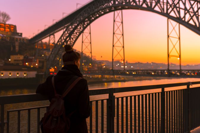 Woman looking at river and city in evening
