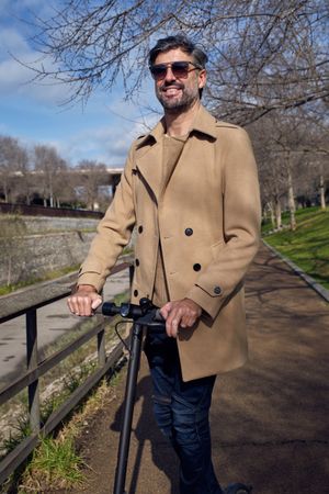 Smiling man on scooter in park