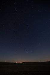City lights in distance on dark starry night