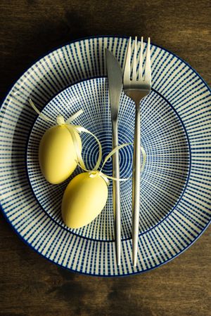 Top view of pastel yellow eggs on blue plates for Easter dinner