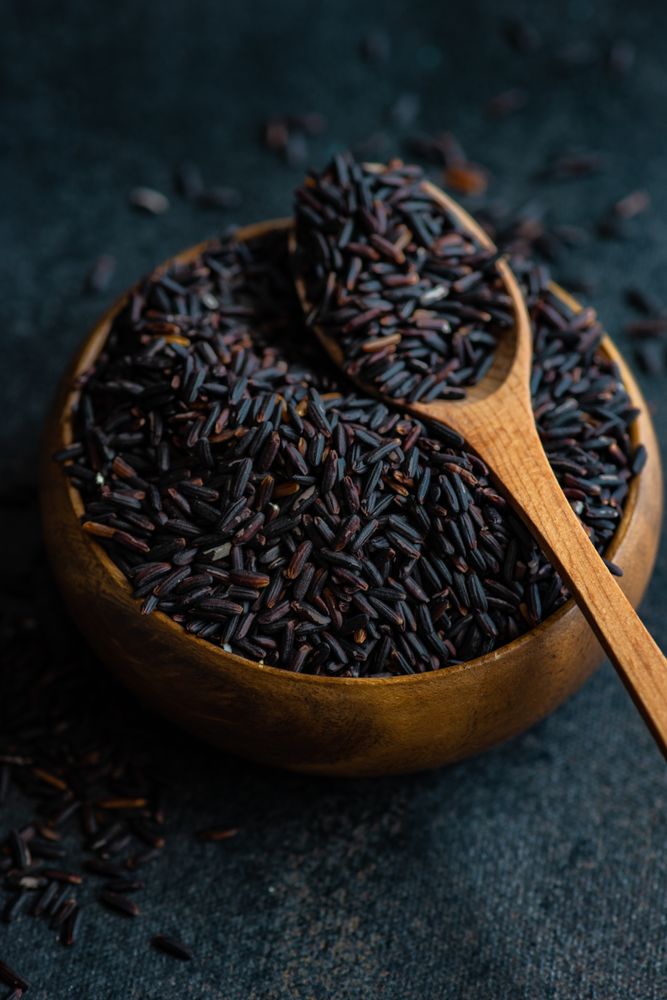 Organic dark rice in bowl with spoon