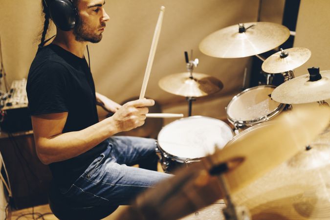 Man with headphones playing on drums
