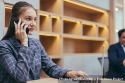 Woman taking phone call in modern office 0J7ad5