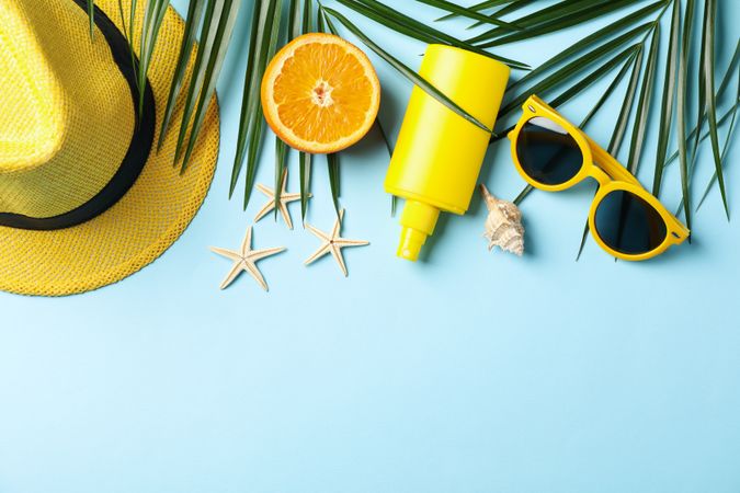 Summer vacation accessories on blue background, space for text