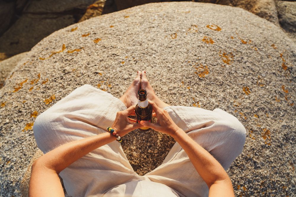 Woman relaxing and drinking beer at beach