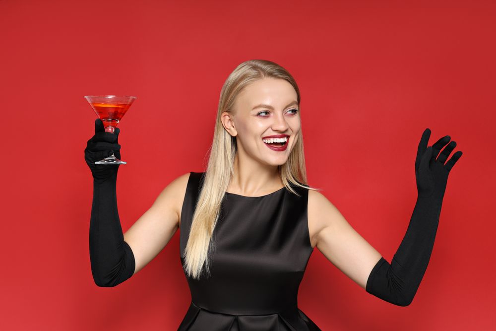 A woman at a party in the style of Halloween with a cocktail in her hands