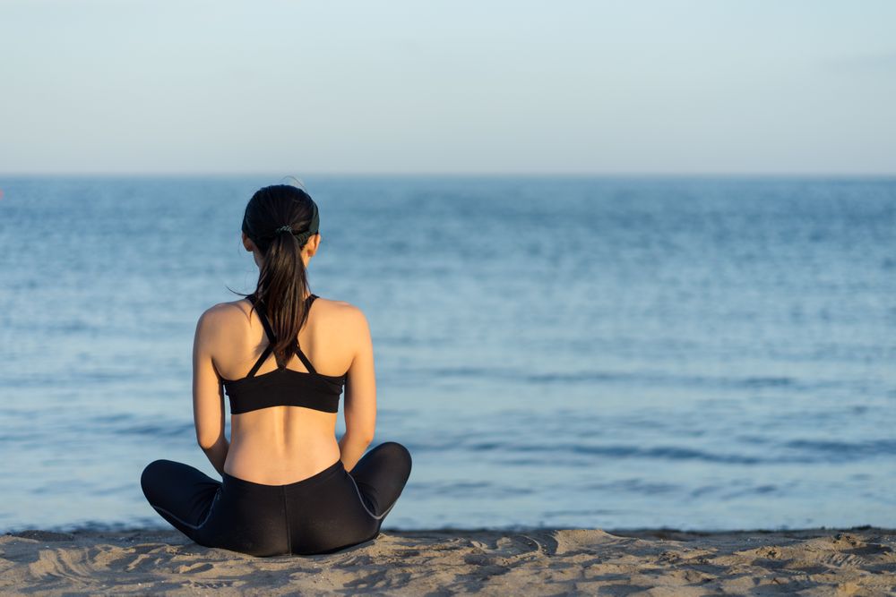 Sportive woman sitting in the on beach