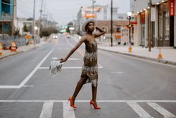 Woman in red heels holding a newspaper walking across the crosswalk during daytime