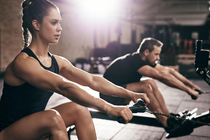 Close up of woman doing intense cardio workout on row machine